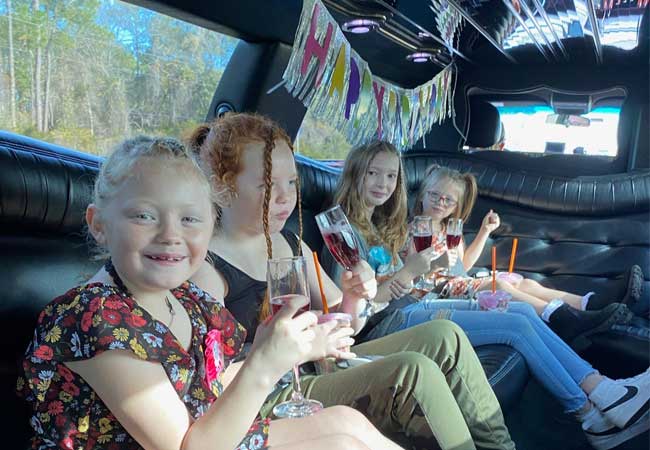 Happy children on a birthday limousine ride