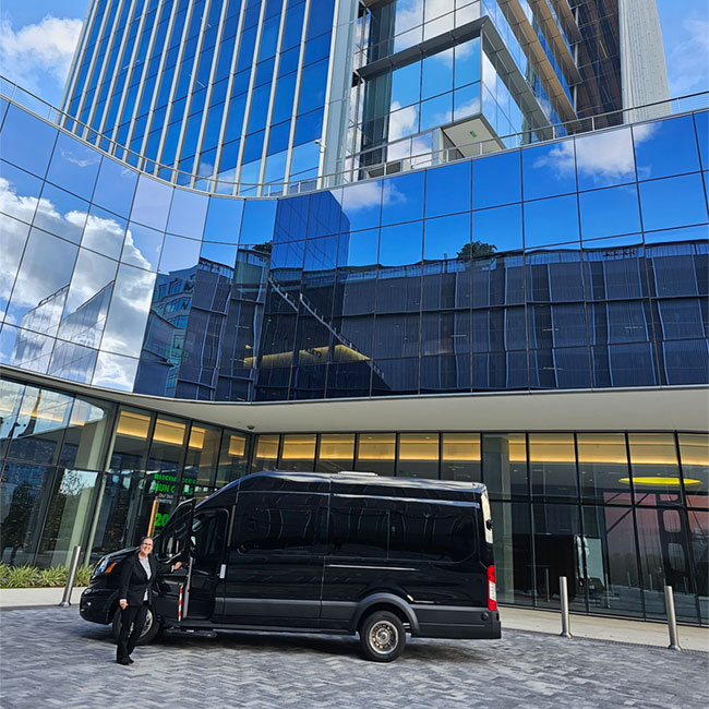 14-passenger-executive-transportation-vehicle-and-driver-parked-in-front-of-building